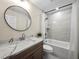 Bathroom featuring a marble vanity, round mirror, and a shower-tub combo at 6615 Callanwalde Ct, Suwanee, GA 30024