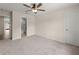 Cozy bedroom with neutral carpet, a ceiling fan, and a door to a bathroom at 6615 Callanwalde Ct, Suwanee, GA 30024
