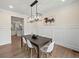 Stylish dining room with hardwood floors, modern lighting, and wainscoting, creating a welcoming atmosphere at 6615 Callanwalde Ct, Suwanee, GA 30024