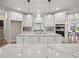 Modern kitchen with white cabinets, marble countertops, and stainless steel appliances at 6615 Callanwalde Ct, Suwanee, GA 30024