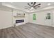 Modern living room featuring an electric fireplace, a mantel, and hardwood floors at 6615 Callanwalde Ct, Suwanee, GA 30024