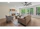 Bright living room with a fireplace, hardwood floors, and large windows offering serene backyard views at 6615 Callanwalde Ct, Suwanee, GA 30024