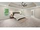 Spacious primary bedroom with tray ceiling, carpet, and natural light at 6615 Callanwalde Ct, Suwanee, GA 30024