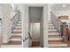 Wood staircase with iron railings and views to two different floors at 6615 Callanwalde Ct, Suwanee, GA 30024