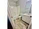 Clean bathroom features a shower-tub combo, white cabinets, and wood-look tile at 75 Davis Mill Dr, Dallas, GA 30157