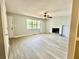 Inviting living room with a cozy fireplace, ceiling fan, and large window, perfect for relaxing and entertaining at 75 Davis Mill Dr, Dallas, GA 30157