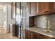 Wet bar features a brass faucet, gray countertop, and dark brown cabinets with silver hardware at 810 Kenry Ct, Atlanta, GA 30342