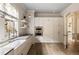 Farmhouse kitchen features stainless appliances, white cabinets, and large sink beneath sunny window at 810 Kenry Ct, Atlanta, GA 30342