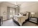 Serene main bedroom with tray ceiling, neutral color palette, and window with floral curtains, offering a relaxing atmosphere at 810 Kenry Ct, Atlanta, GA 30342