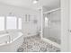 Bright bathroom with soaking tub, glass shower, and decorative tile flooring at 101 Saddlehorn Ct, Woodstock, GA 30188