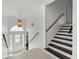 Inviting foyer with staircase and a stylish pendant light fixture above the door with decorative glass at 101 Saddlehorn Ct, Woodstock, GA 30188