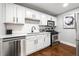 Modern kitchen featuring stainless steel appliances, white cabinets, and dark hardwood floors at 215 Piedmont Ne Ave # 1509, Atlanta, GA 30308