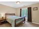 Bedroom features a metal-framed bed, neutral walls, a window with brown curtains, and a bedside table with a lamp at 2810 Olde Town Park Dr, Norcross, GA 30071