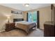 Bedroom features hardwood floors, a neutral color scheme, a window with brown curtains, and a bedside table with a lamp at 2810 Olde Town Park Dr, Norcross, GA 30071