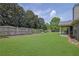 Large backyard with a lush green lawn, wooden fence and a covered patio at 3425 Sweet Basil Ln, Loganville, GA 30052