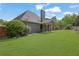 Well-manicured backyard with a covered patio, lush lawn, and privacy fence at 3425 Sweet Basil Ln, Loganville, GA 30052