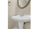 This bathroom features a pedestal sink, round mirror, and neutral paint at 3425 Sweet Basil Ln, Loganville, GA 30052
