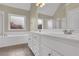 Bathroom featuring double sinks, a soaking tub, and a shower at 3425 Sweet Basil Ln, Loganville, GA 30052