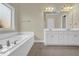 Bathroom boasts a soaking tub and large vanity with great lighting at 3425 Sweet Basil Ln, Loganville, GA 30052