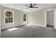 Spacious bedroom featuring neutral colors, carpeted floor, two windows and ceiling fan with light at 3425 Sweet Basil Ln, Loganville, GA 30052