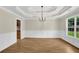 Bright dining area featuring hardwood floors, wainscoting, and a modern chandelier at 3425 Sweet Basil Ln, Loganville, GA 30052