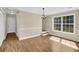 This dining area features a large window, chandelier, beautiful hardwood floors, and neutral paint at 3425 Sweet Basil Ln, Loganville, GA 30052