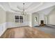 Elegant dining room with hardwood floors, wainscoting, tray ceiling and a chandelier at 3425 Sweet Basil Ln, Loganville, GA 30052