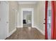 Bright foyer featuring hardwood floors, a red front door, and white trim details at 3425 Sweet Basil Ln, Loganville, GA 30052