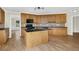Well-lit kitchen featuring wooden cabinets, dark countertops, and hardwood floors at 3425 Sweet Basil Ln, Loganville, GA 30052