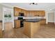 Classic kitchen showcasing wood cabinets, black appliances, and a granite countertop island at 3425 Sweet Basil Ln, Loganville, GA 30052