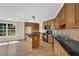 Bright kitchen with black appliances, wood cabinets, granite countertops, and a center island with a view at 3425 Sweet Basil Ln, Loganville, GA 30052