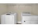 Laundry room includes a white washer and dryer, shelving, and neutral paint at 3425 Sweet Basil Ln, Loganville, GA 30052