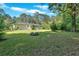Lush backyard featuring green lawn, mature trees, and a fire pit area, perfect for relaxation at 3951 Lindley Dr, Powder Springs, GA 30127