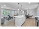 Open concept living with island connecting living, dining, and kitchen areas, bathed in natural light at 3951 Lindley Dr, Powder Springs, GA 30127
