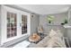 Cozy sunroom with comfortable seating and bright natural light through double doors and large windows at 3951 Lindley Dr, Powder Springs, GA 30127