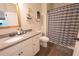 Well-lit bathroom with granite counters, white cabinets, and a shower/tub combo at 453 Mulberry Rock Rd Rd, Temple, GA 30179