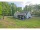 The back of this home offers a covered porch and sprawling back yard with mature trees at 453 Mulberry Rock Rd Rd, Temple, GA 30179