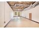 Spacious unfinished basement with exposed ceiling, concrete floors, and double doors at 929 Hampton Nw Trl, Lilburn, GA 30047