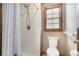 Bathroom with shower, toilet, window, and wood trim at 929 Hampton Nw Trl, Lilburn, GA 30047
