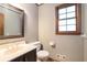 Well-lit bathroom featuring a vanity, toilet, and window for natural light at 929 Hampton Nw Trl, Lilburn, GA 30047