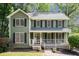 Charming two-story home featuring a welcoming front porch and a well-maintained lawn with mature trees at 929 Hampton Nw Trl, Lilburn, GA 30047