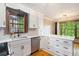 Bright kitchen featuring white cabinetry, stainless steel appliances, quartz countertop, and a view of the trees at 929 Hampton Nw Trl, Lilburn, GA 30047