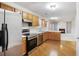 Modern kitchen with stainless steel appliances, hardwood floors, light colored cabinets, and an open view to the living area at 1188 To Lani Farm Rd, Stone Mountain, GA 30083