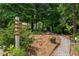 A gravel path leads through a landscaped yard with a directional sign, beautiful plantings and a garden at 148 Waverly Way # 10, Atlanta, GA 30307