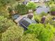 Aerial view of the home with manicured lawns, a large driveway, and a wooded backyard at 1633 Clifton Downs Ct, Kennesaw, GA 30144
