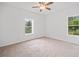 Bright bedroom with neutral carpet, white walls, a ceiling fan, and windows overlooking the outdoors at 1633 Clifton Downs Ct, Kennesaw, GA 30144