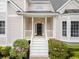 Inviting front porch with white railings and a black front door, surrounded by lush greenery at 1633 Clifton Downs Ct, Kennesaw, GA 30144