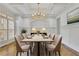 Formal dining room with decorative chandelier, tray ceiling, and wainscoting at 2932 Springbluff Ln, Buford, GA 30519