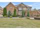 Charming two-story brick home with stone accents, manicured lawn, and covered front porch at 2932 Springbluff Ln, Buford, GA 30519