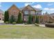 Inviting two-story brick and stone home with a covered porch and mature landscaping at 2932 Springbluff Ln, Buford, GA 30519
